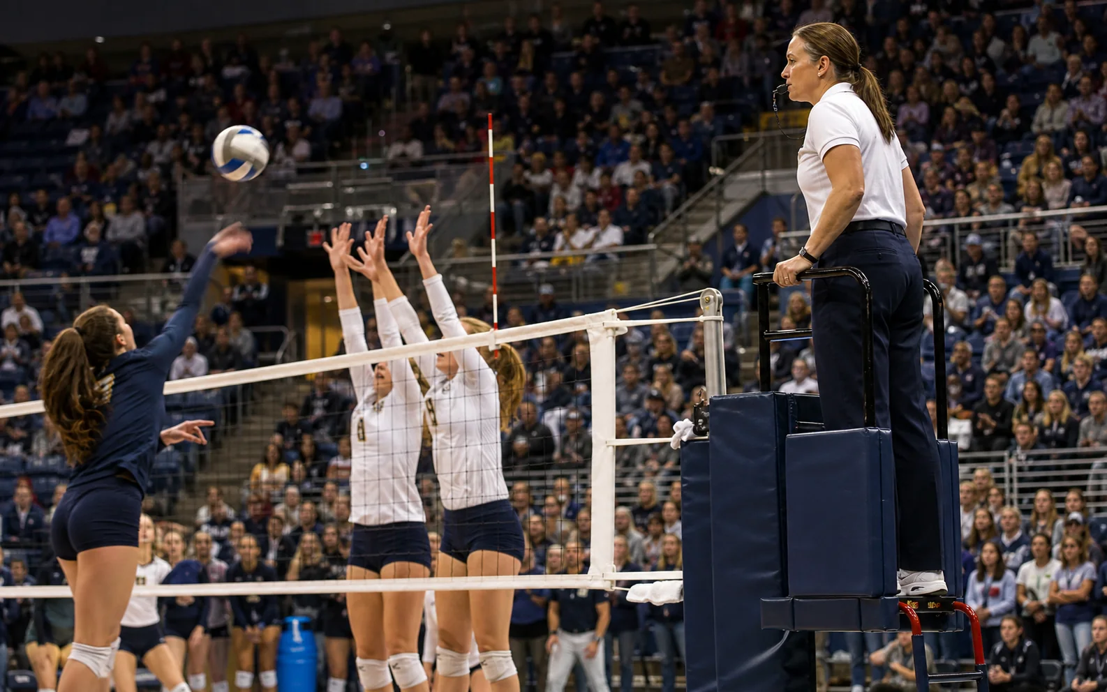 Female volleyball referee judging live net action